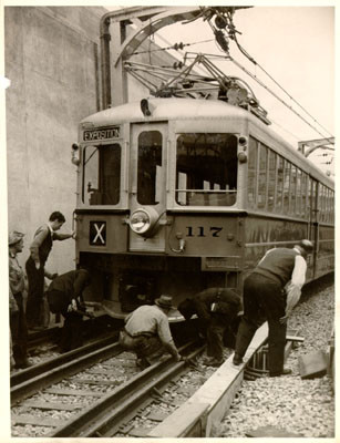 [Workers examining a San Francisco-Oakland Bay Bridge electric railway train]