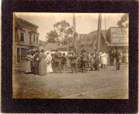 [Crowd watching a marching band at corner of Diamond and Chenery]