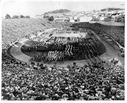 [Crowd watching marching band on field at Kezar Stadium]