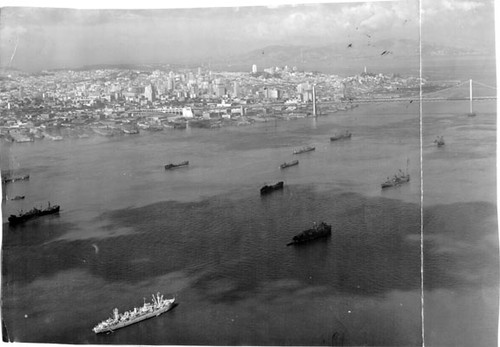 [Fleet of cargo ships at anchor beside Bay Bridge]