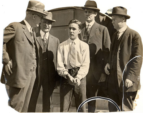 [Detective Sergeant Bernard J. McDonald (left) with three police officers and a detainee]