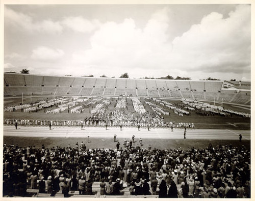 [Crowd of people watching a marching band at Kezar Stadium]