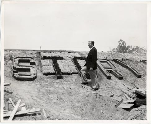 Walt Disney examining the construction of Story Book Land, a new
