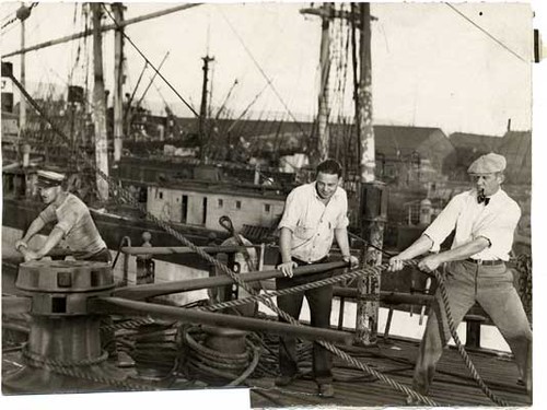 [Crew members manning the capstan on the sailing ship "Pacific Queen" (also known as the "Balclutha")]