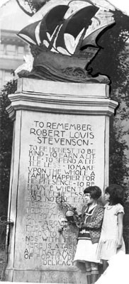 [Two little girls reading the words inscribed on the Robert Louis Stevenson monument]