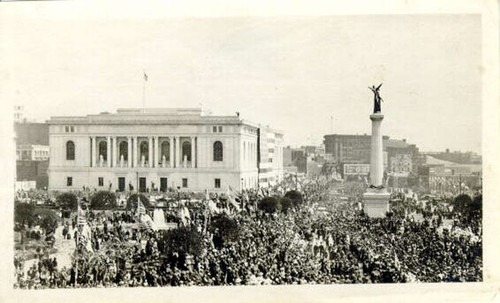 [Crowds of people gathering in the Civic Center Plaza across from the San Francisco Public Library]