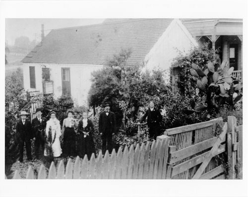 [Cord Beneke, Mueller, Marie Mueller, Elise Tietz, Gesine Beneke, Kurt Beneke, John Beneke pose next to cottage at 657 Chenery, looking south-west towards Glen Park School]