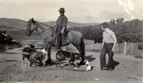 [Two unidentified people with four dogs and a horse in Visitacion Valley]