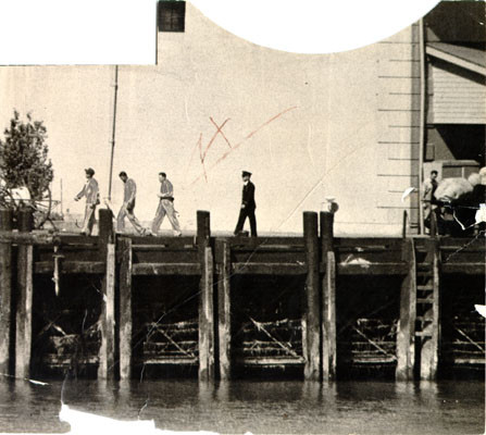 [Guard walking with three prisoners at Alcatraz Prison]