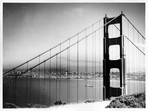 [View of the north tower of the Golden Gate Bridge with San Francisco visible in the background]