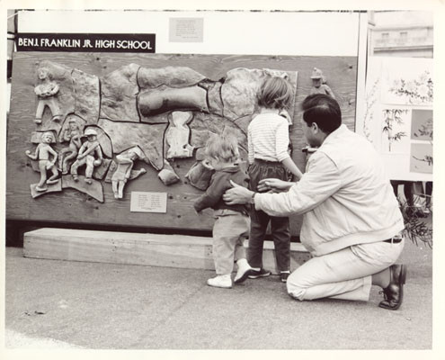 [Children and adult looking at relief art work belonging to Benjamin Franklin Junior High School]