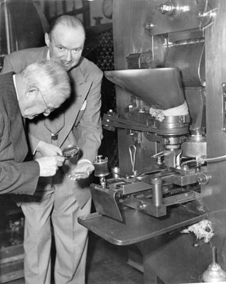 [Two unidentified people inspecting freshly minted coins at the U. S. Mint in San Francisco]