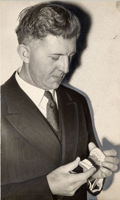 [Officer Francis X. Latulipe looking at pattern of Henry Golombek's teeth]