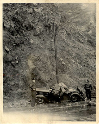 [Police officers Robert Unruh and John Brymner inspecting a car damaged by a Telegraph Hill rock slide]