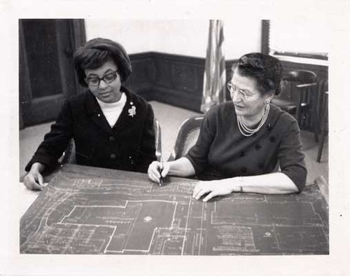 [Two women looking at architectural drawing of the Western Addition Branch Library]