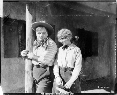 [Publicity still featuring Roscoe "Fatty" Arbuckle and Jane Acker in "The Roundup"]