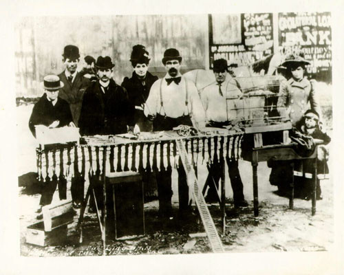 [Birdman flanked by a group of people at the Cliff House, Ocean Beach]