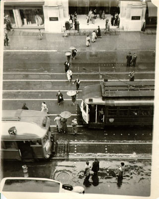 [Pedestrians crossing Market Street on a rainy day]