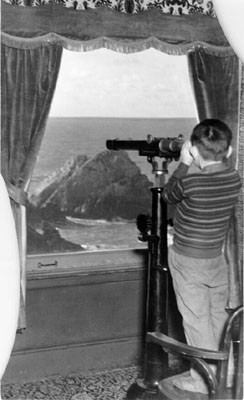 [Boy looking through telescope from Cliff House]