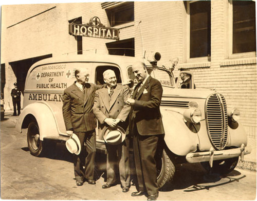 [Dr. Edmund Butler, Chief Surgeon, James O'Dea, Chief Steward, and Dr. J. C. Geiger standing next to a new ambulance in front of Central Emergency Hospital]