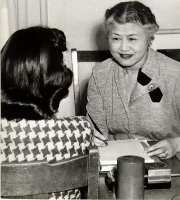 [Rose Chew interviewing a young Chinese immigrant woman at the International Institute, a Community Chest agency]