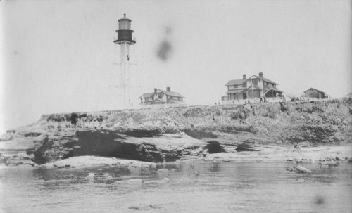 The Point Loma lighthouse and caretakers houses when men were gathered at the lighthouse to salvage the wreck of the "Loma" a yacht given to the Marine Biological Association of San Diego by E.W. Scripps for research purposes; it ran aground near the lighthouse on July 25, 1906. The Association became the Scripps Institution of Oceanography. July 25, 1906