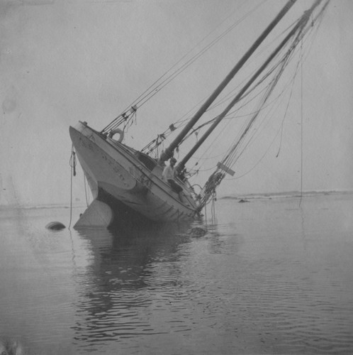 Boy sitting on the wreck of the "Loma", the boat given to the Marine Biological Association of San Diego by E.W. Scripps for research purposes; it ran aground near the Point Loma lighthouse on July 25, 1906. The Association became the Scripps Institution of Oceanography. July 25, 1906