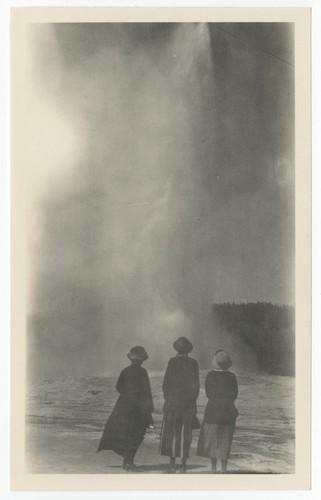 Three women viewing Old Faithful, Yellowstone National Park