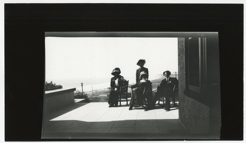 Ed Fletcher with unidentified women on porch of Stratford Inn