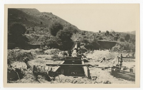 Laying steel pipeline for repairs to the San Diego flume following the flood of 1916