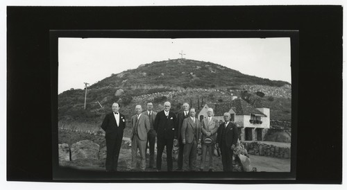 Group portrait outside of home on Mount Helix, with cross in background