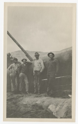 Laborers posing by a steel pipe section of the San Diego flume