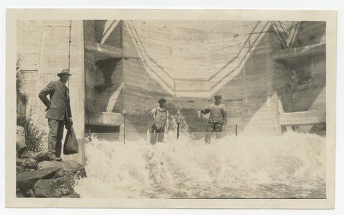 Men catching fish in net from spillway on Lake Murray Dam