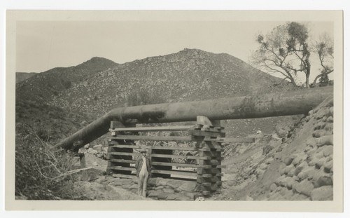 Man posing by supports for a steel pipe section of the San Diego flume