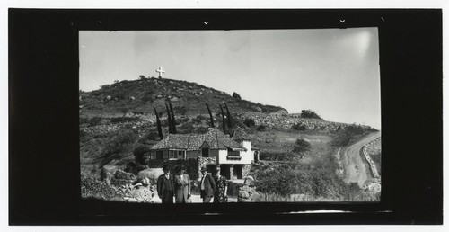 Group portrait outside of home on Mount Helix, with cross in background