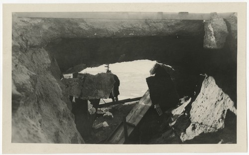 Man surveying a break in the dam at Torrey Pines