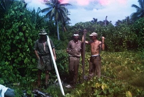 Henry W. (Henry William) Menard, Robert S. (Robert Sinclair) Dietz, and unidentified man, on Bikini Atoll of the Marshall Islands during the Midpac Expedition. Menard was a marine geology professor and Dietz was a geophysicist and oceanographer who conducted pioneering research. Both taught at the Scripps Institution of Oceanography