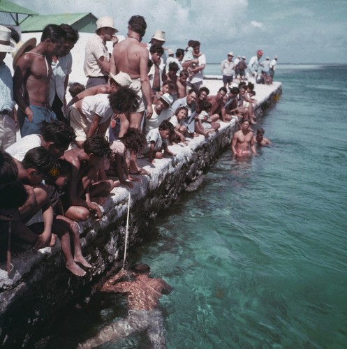 Takaroans on the quay watching pearl divers prepare to go below