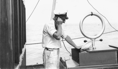 [Man and radio aboard R/V E.W. Scripps ]