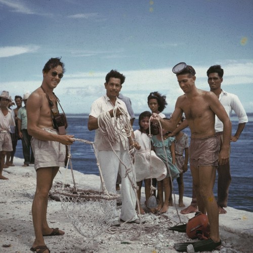 Henri Rotschi, left, village chief Paniora, center, and Willard Bascom, right, holding pearl collecting baskets and weight line in Takaroa