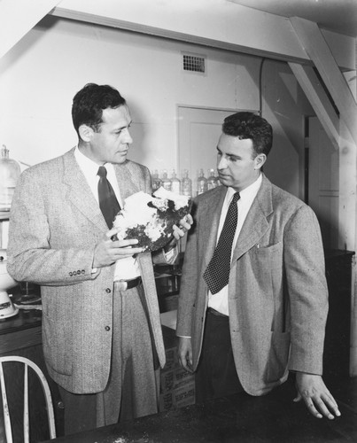 Roger Revelle and Robert Dietz, co-chief scientists on the MidPac Expedition of 1950, discussing significance of lithified globigerina ooze dredged from western Pacific. The Cretaceous fossils enclosed indicated a much younger age than expected--a mystery which remained unresolved until later explained by plate tectonics and continental drift. Shot 3 of 3