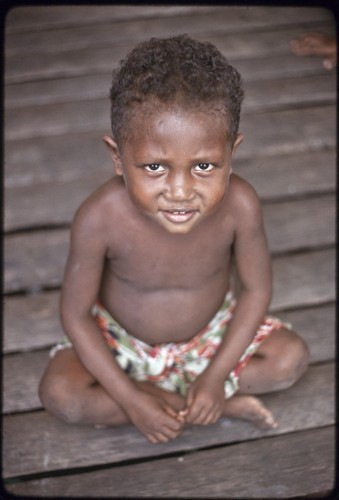 Child sits on the veranda of the Hutchins' house