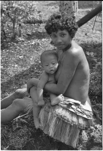 Young woman in short fiber skirt, holding infant