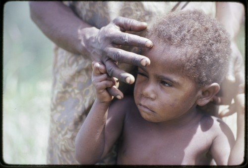 Western Highlands: young child clings to a woman's hand