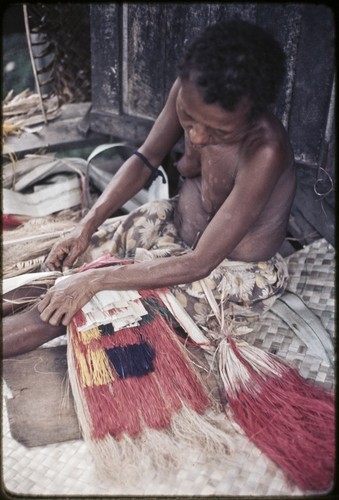 Weaving: woman makes multi-layer, dyed skirt from banana and pandanus-leaf fibers, she sits on mat of woven pandanus leaves