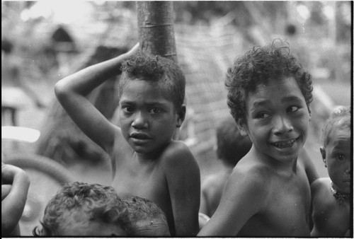 Children, one looking at camera, another smiling