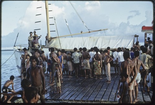 Sailboat named Laba, docked in Losuia, people crowded around