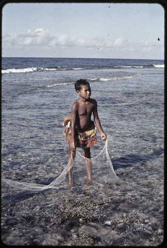 Fishing: girl holds small net on the fringing reef near Wawela village