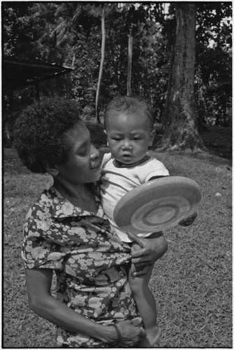 Woman with infant holding a flying disc