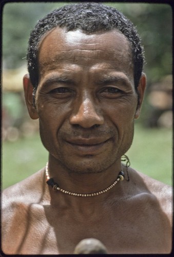 Man wearing a shell bead necklace